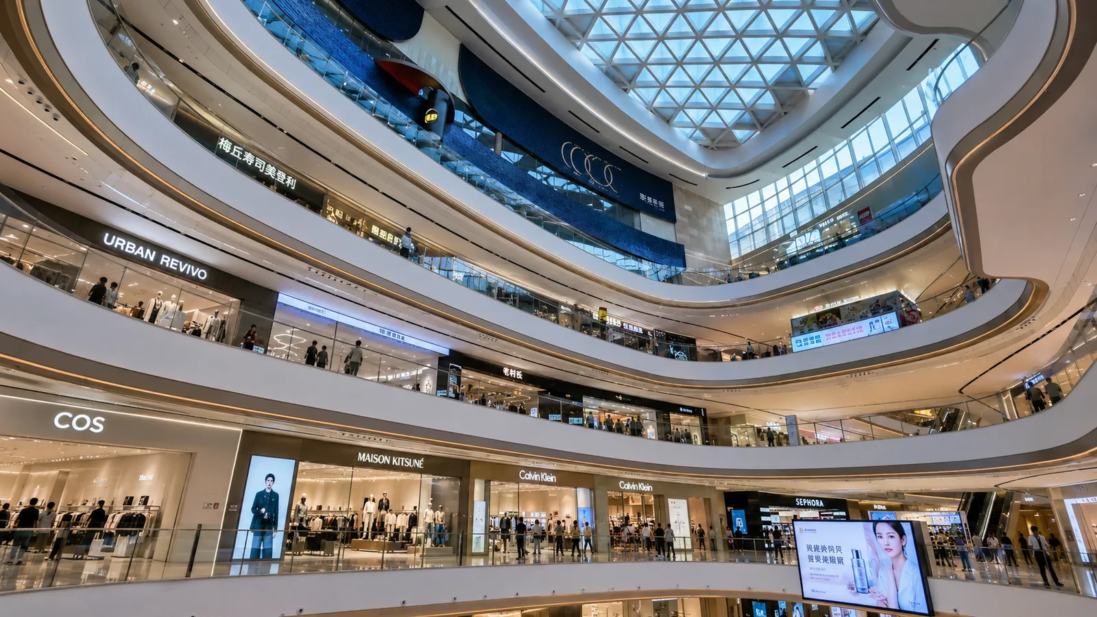 A multi-level Chinese shopping mall with restaurants, a cinema, fashion stores and people riding escalators