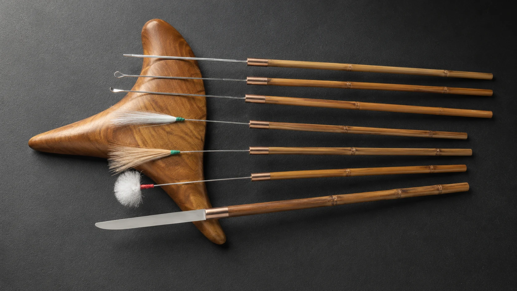 Fine metal ear-cleaning tools, brushes, feathers, and scoops arranged in a Chengdu practitioner's kit