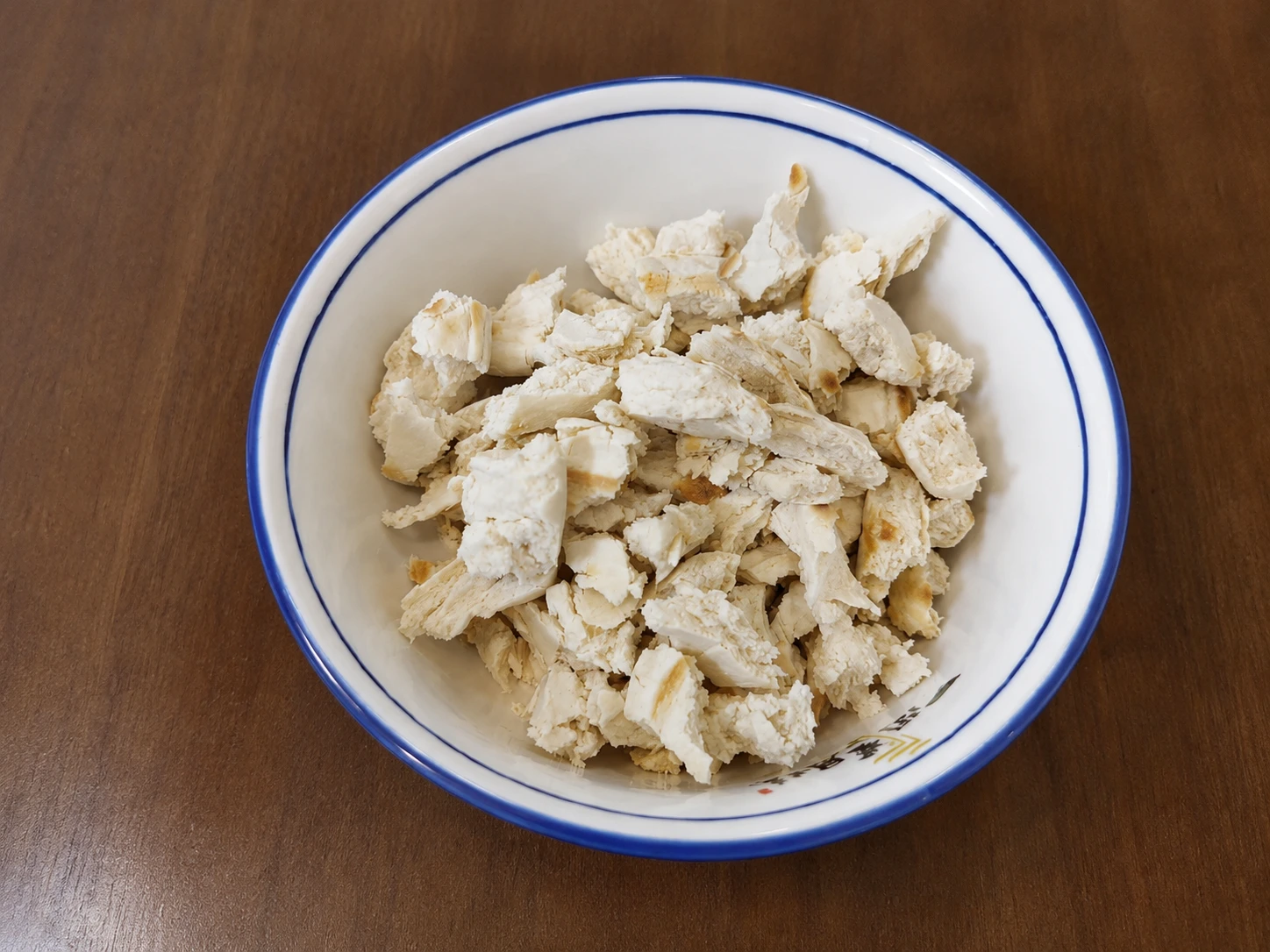 A pair of hands tearing a round baiji mo flatbread into small, bite-sized pieces