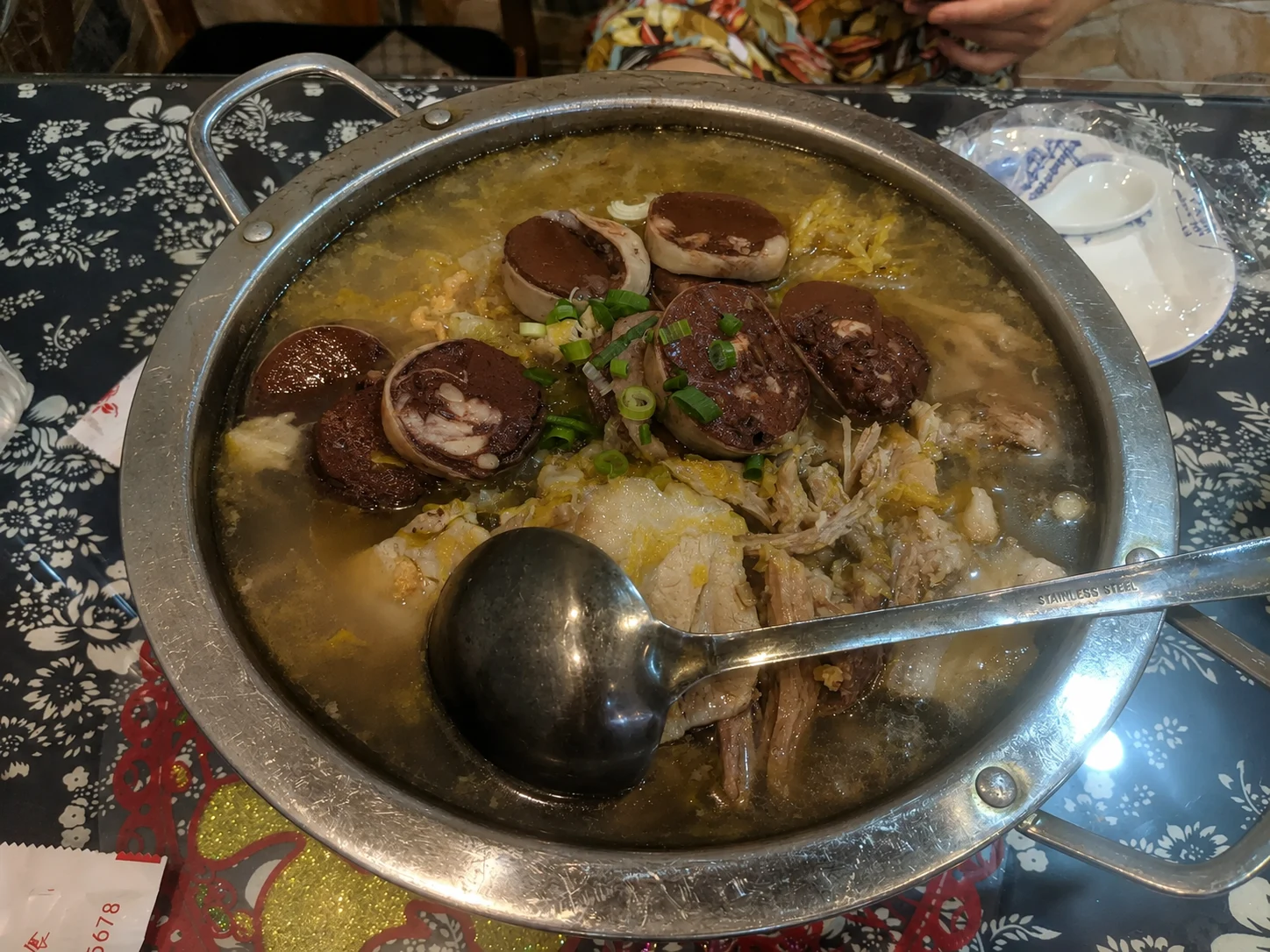 A rustic Harbin winter stew with pork blood sausage, pickled cabbage, and sliced pork