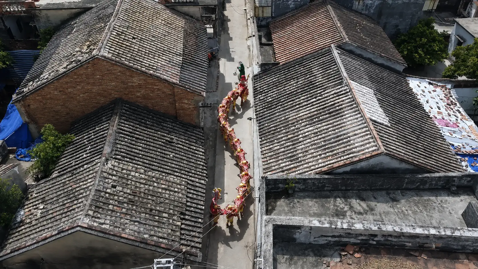 Human dragon dance winding through narrow alley