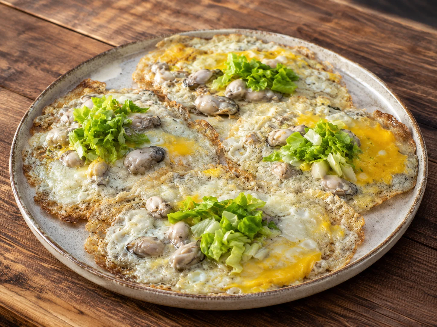 A sizzling oyster omelette on a hot griddle
