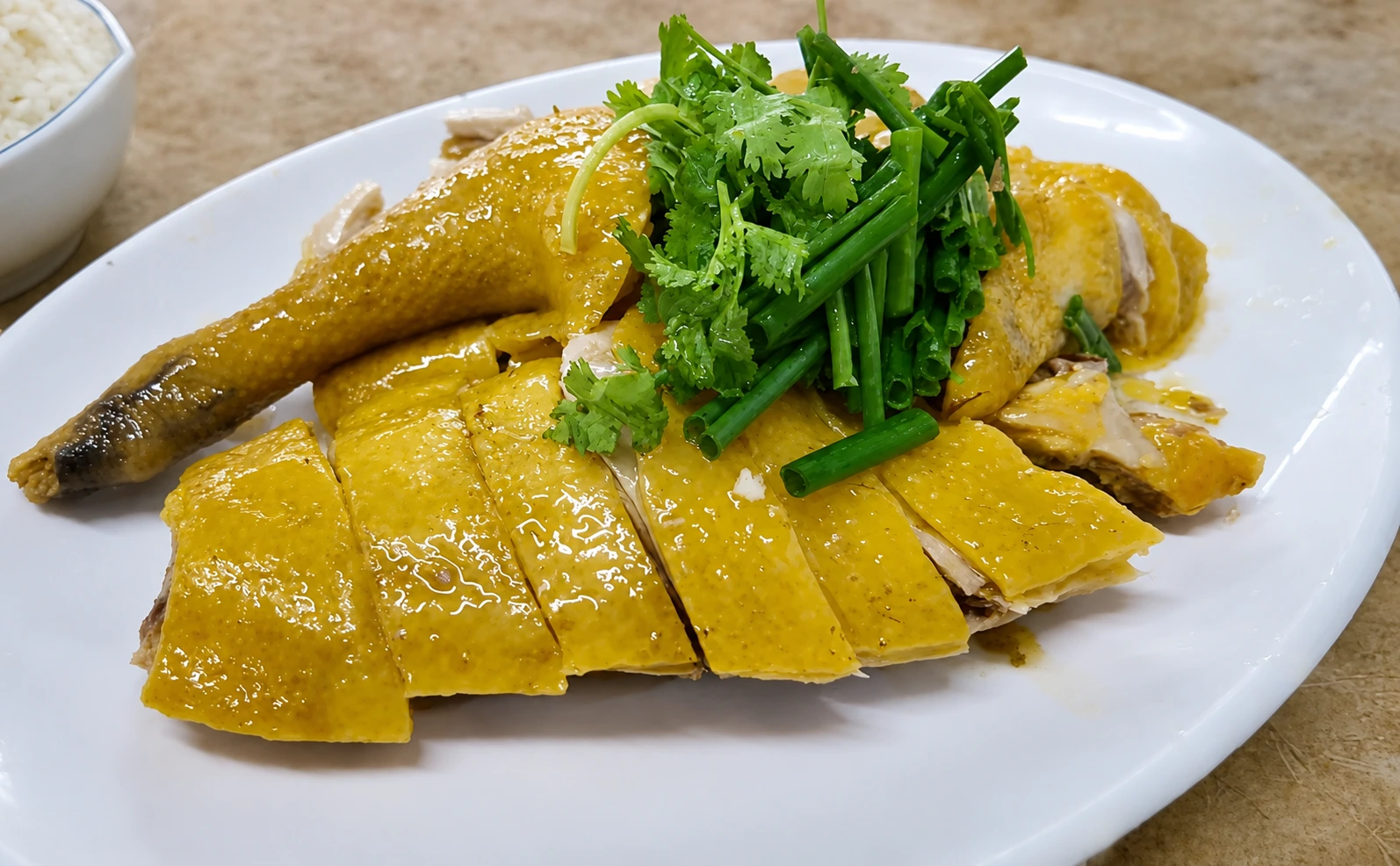 A plate of sliced white-cut chicken arranged neatly on a table