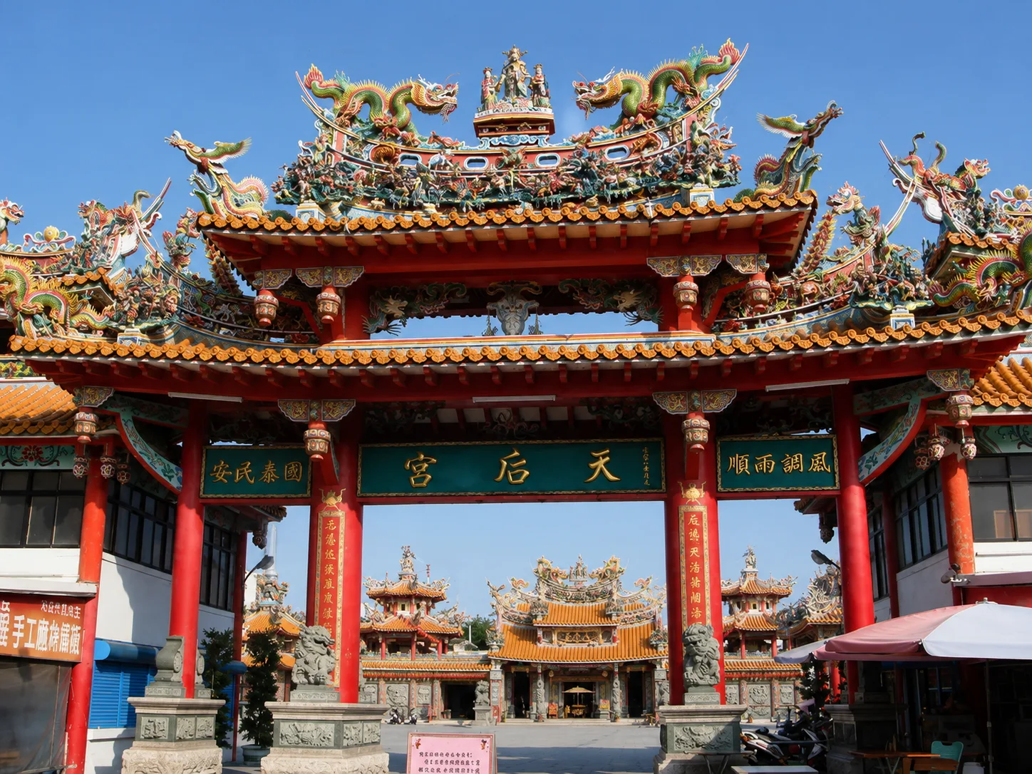 Incense smoke rises in dense spirals inside a traditional Chinese temple, with a Mazu statue visible through the haze