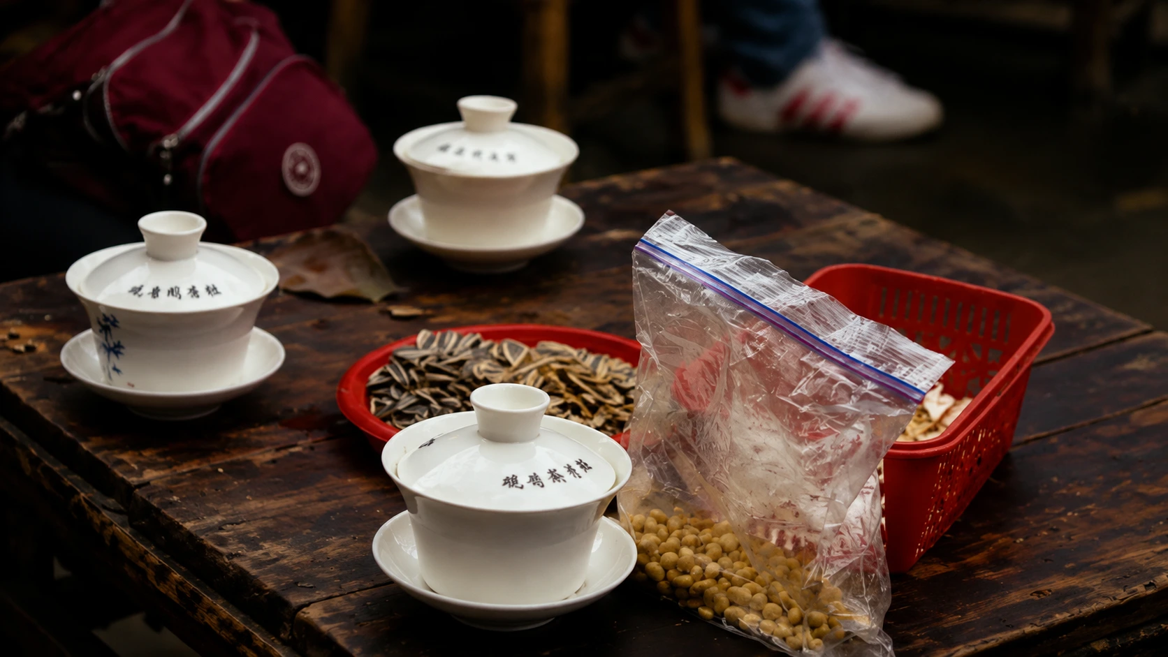 A teahouse table holds a cup of tea and a dish of sunflower seeds