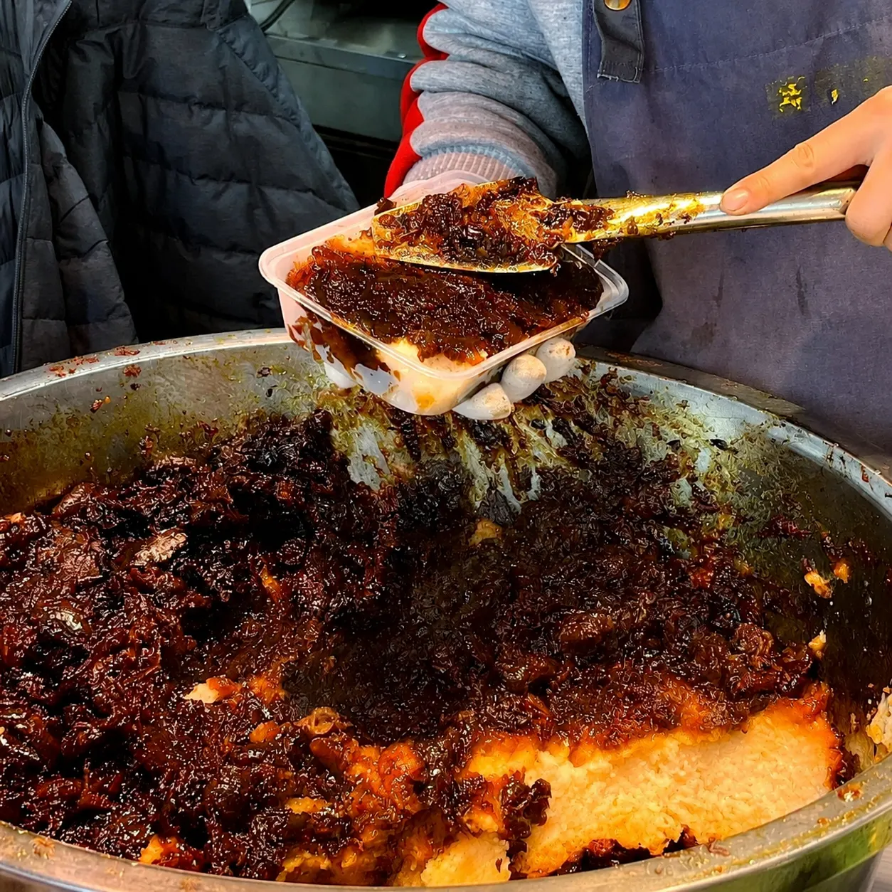 Vendor packing Zenggao with an iron spatula