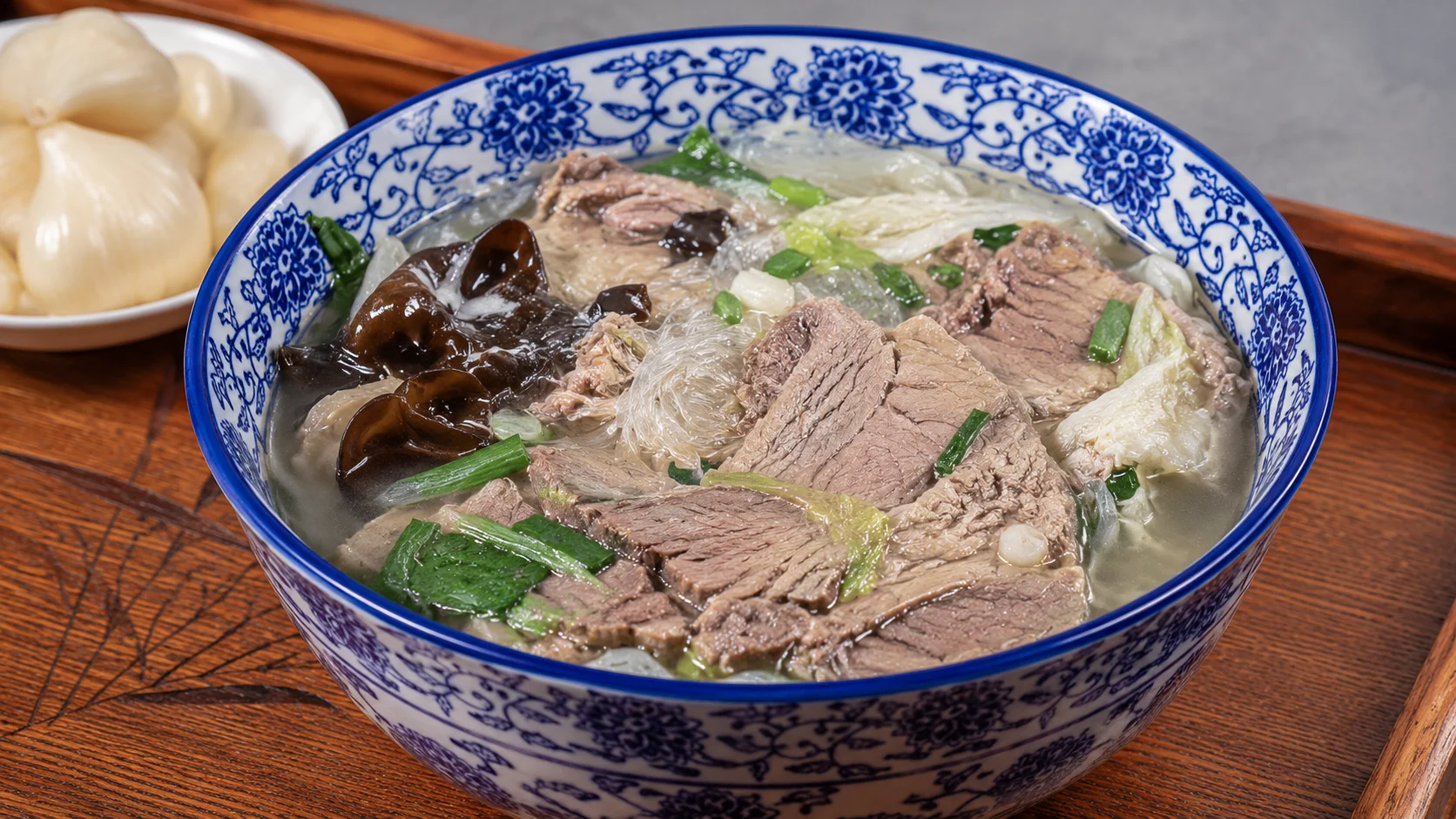 A steaming bowl of lamb paomo with torn flatbread and clear broth