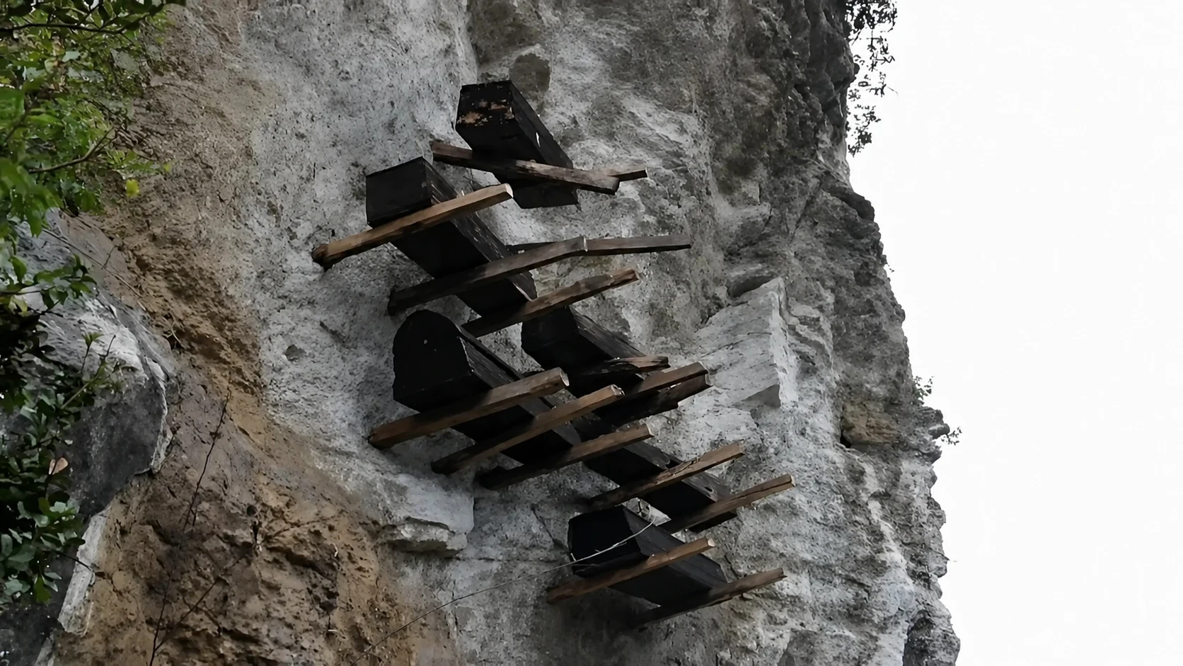 Five dark wooden coffins wedged into natural crevices high on a limestone cliff above the Xiling Gorge in Yichang
